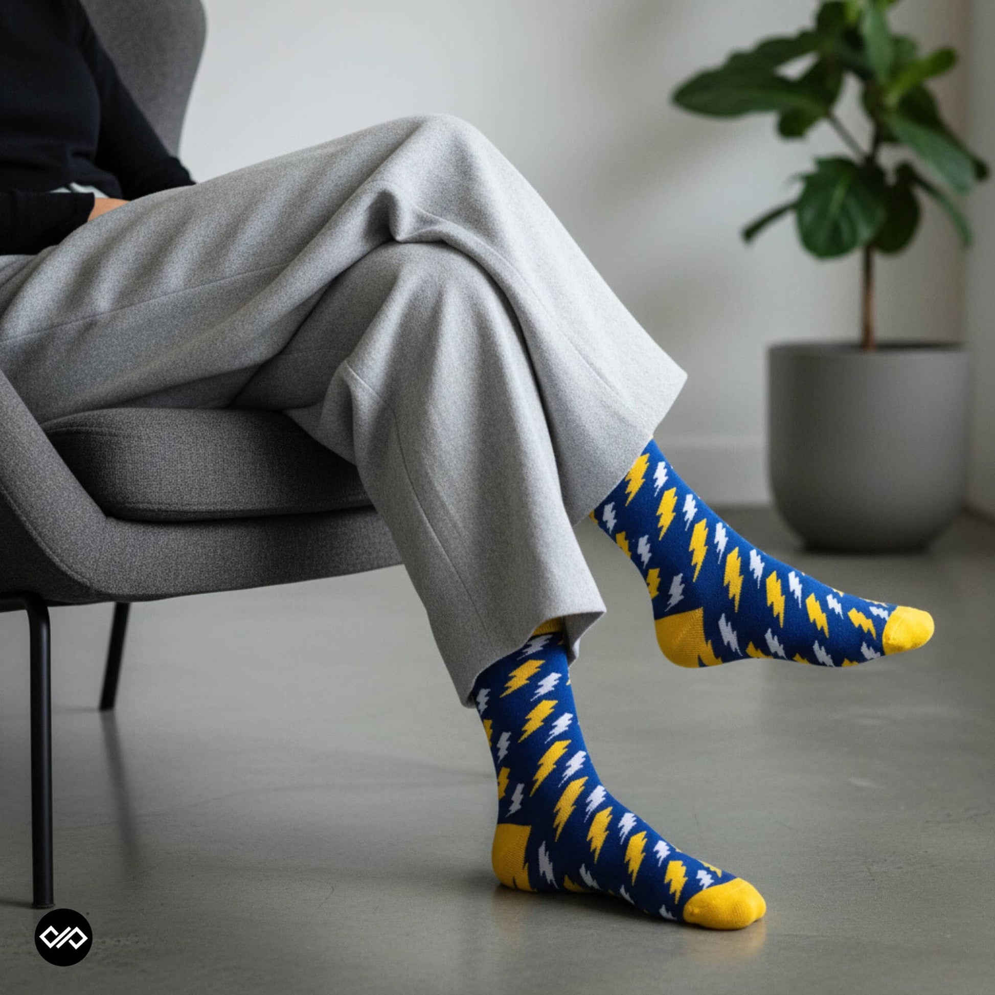 Bolt lightning crew socks styled with grey trousers in a modern living room — Dynamocks