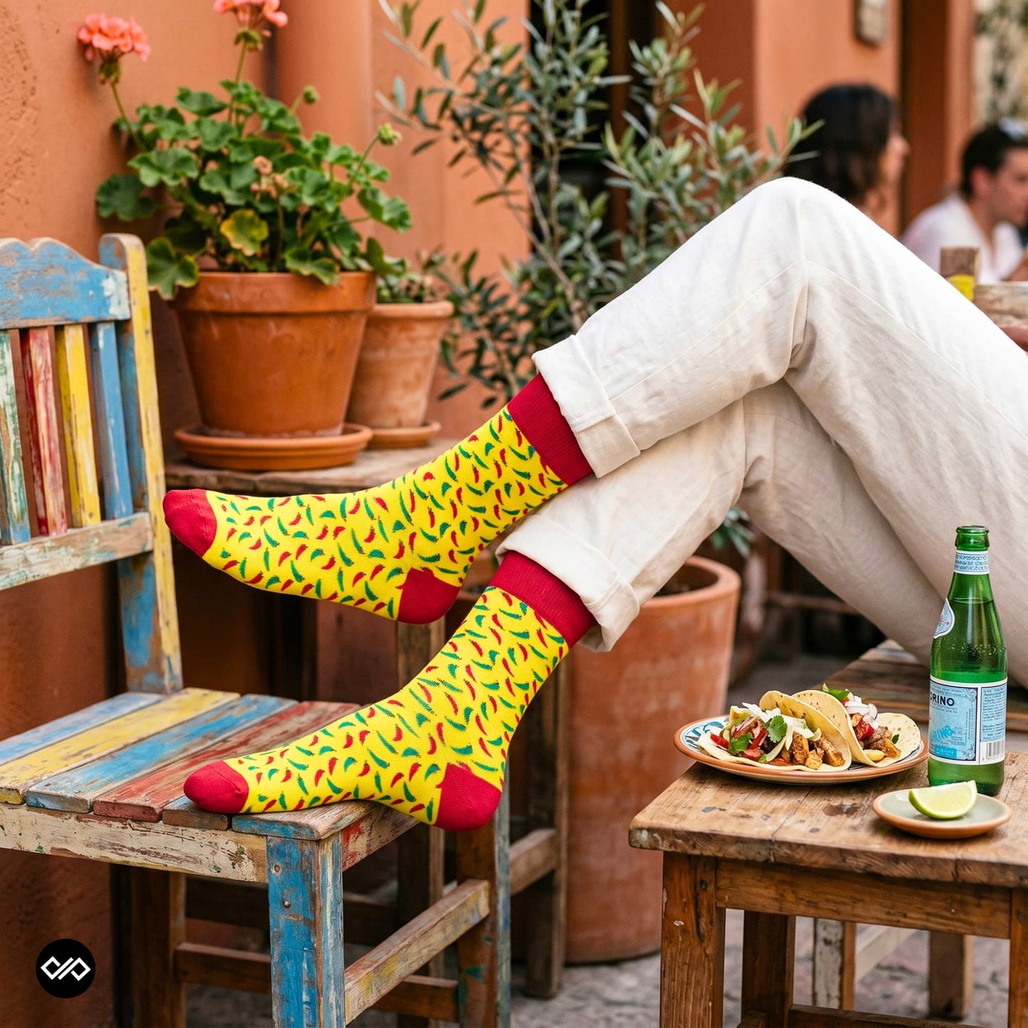 Chillies crew socks styled with rolled cream trousers at a Mexican-style café table with tacos – Dynamocks