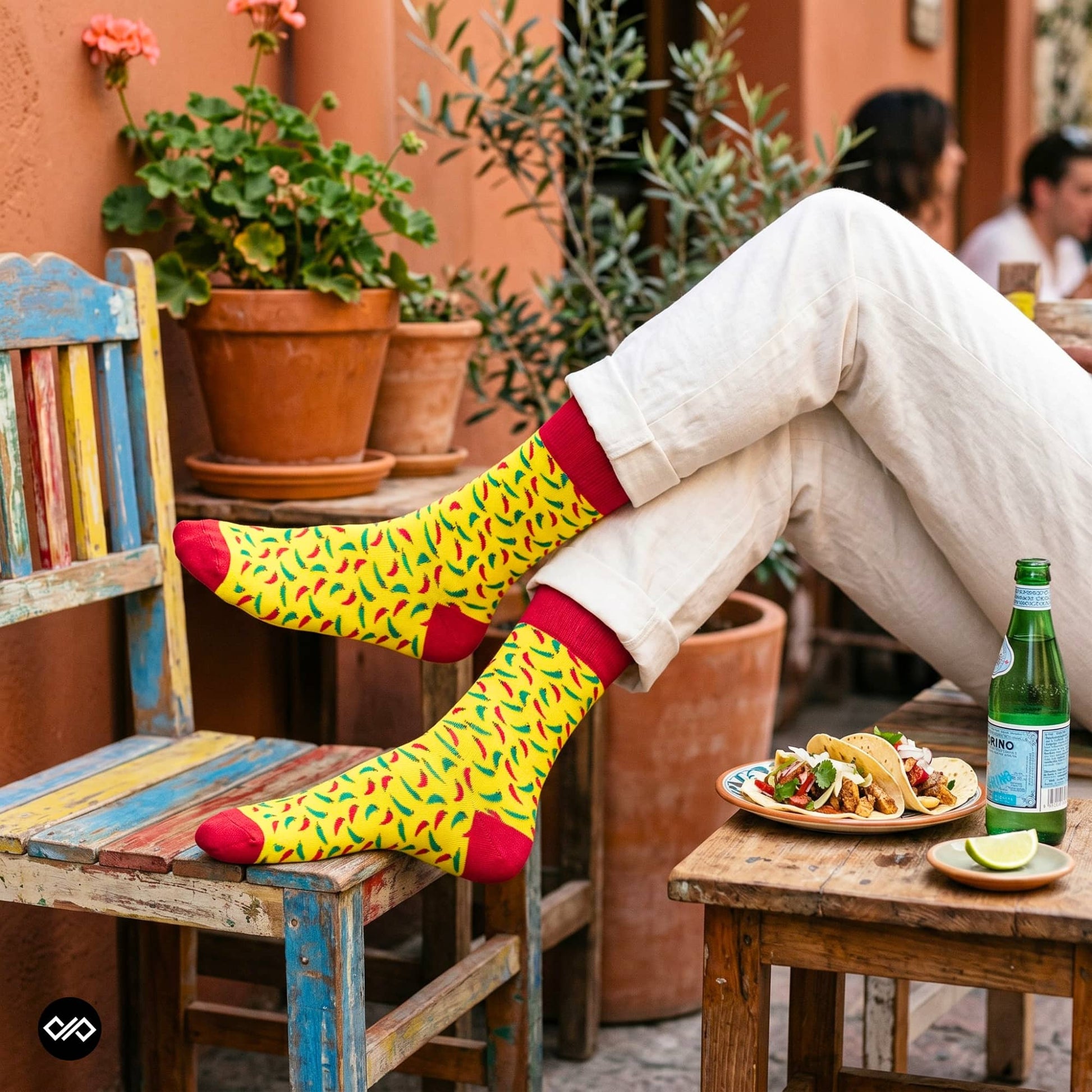 Chillies crew socks styled with rolled cream trousers at a Mexican-style café table with tacos – Dynamocks