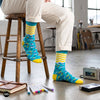 Jolly funky crew socks on wooden stool with art studio backdrop – Dynamocks
