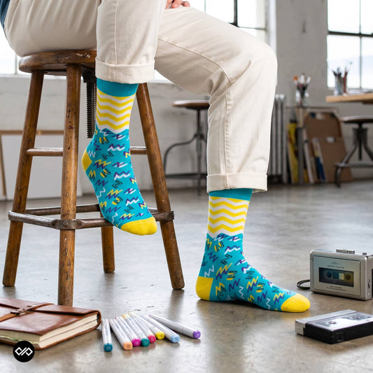 Jolly funky crew socks on wooden stool with art studio backdrop – Dynamocks