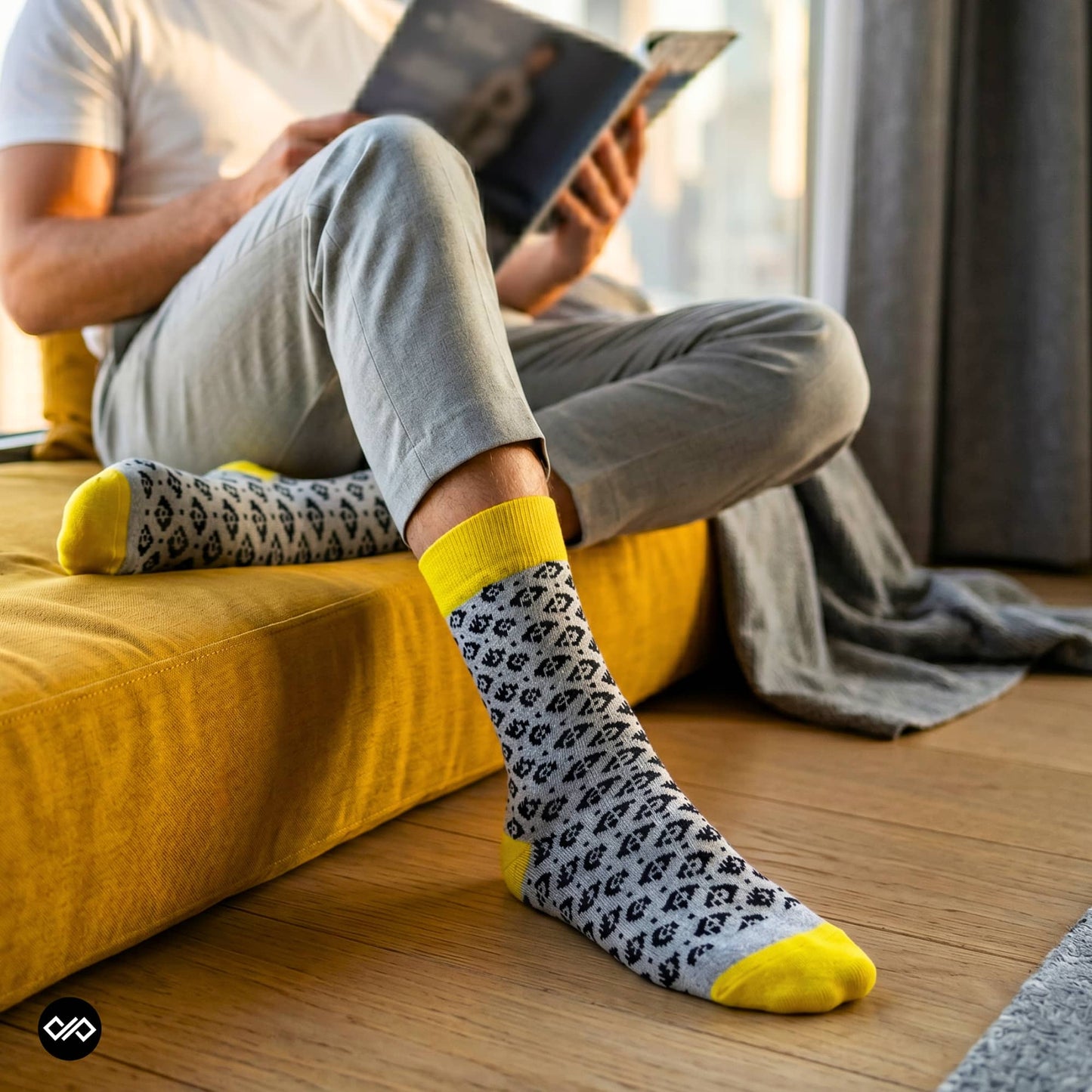 Rogue folk-pattern crew socks worn with light grey chinos on a mustard yellow — Dynamocks
