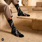 Skeleton crew socks styled with beige linen trousers on a travertine bench — Dynamocks