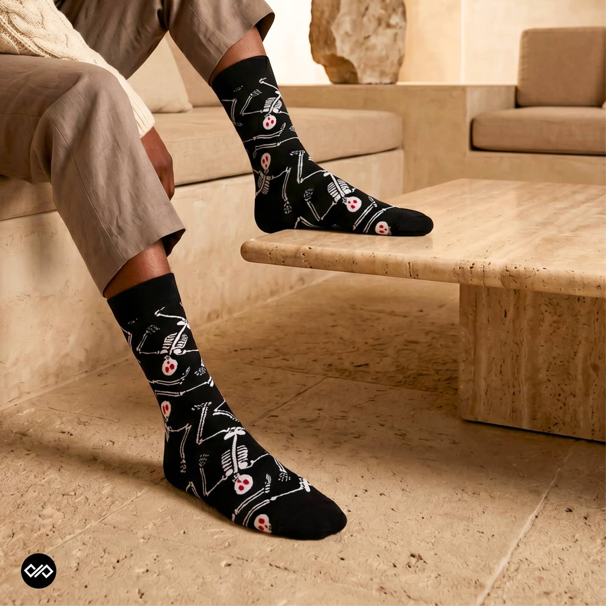 Skeleton crew socks styled with beige linen trousers on a travertine bench — Dynamocks