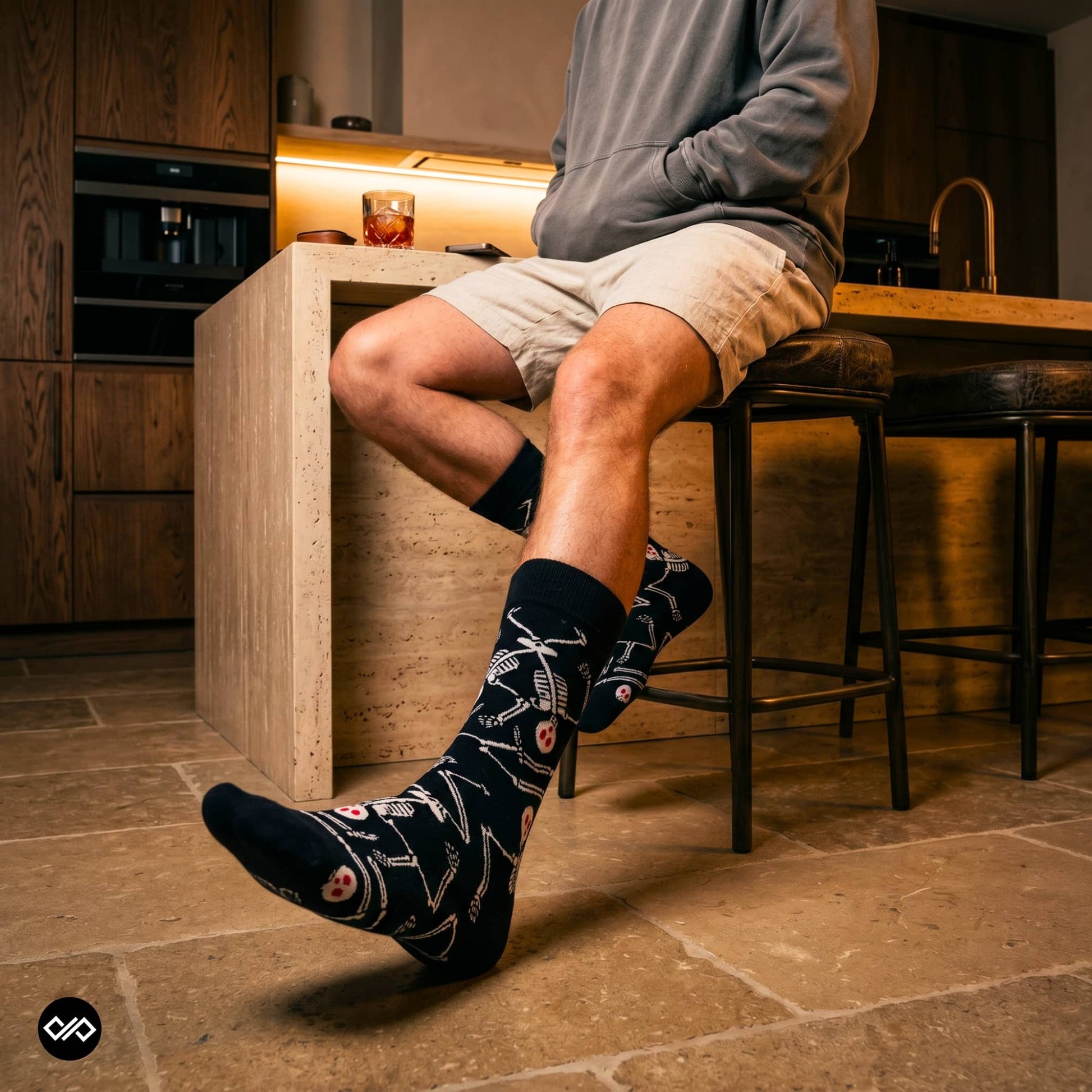 Skeleton crew socks styled with beige shorts and grey hoodie in a modern kitchen — Dynamocks