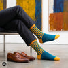 Teal blue and mango striped crew socks for men styled with charcoal trousers and tan loafers at an art gallery — Dynamocks India