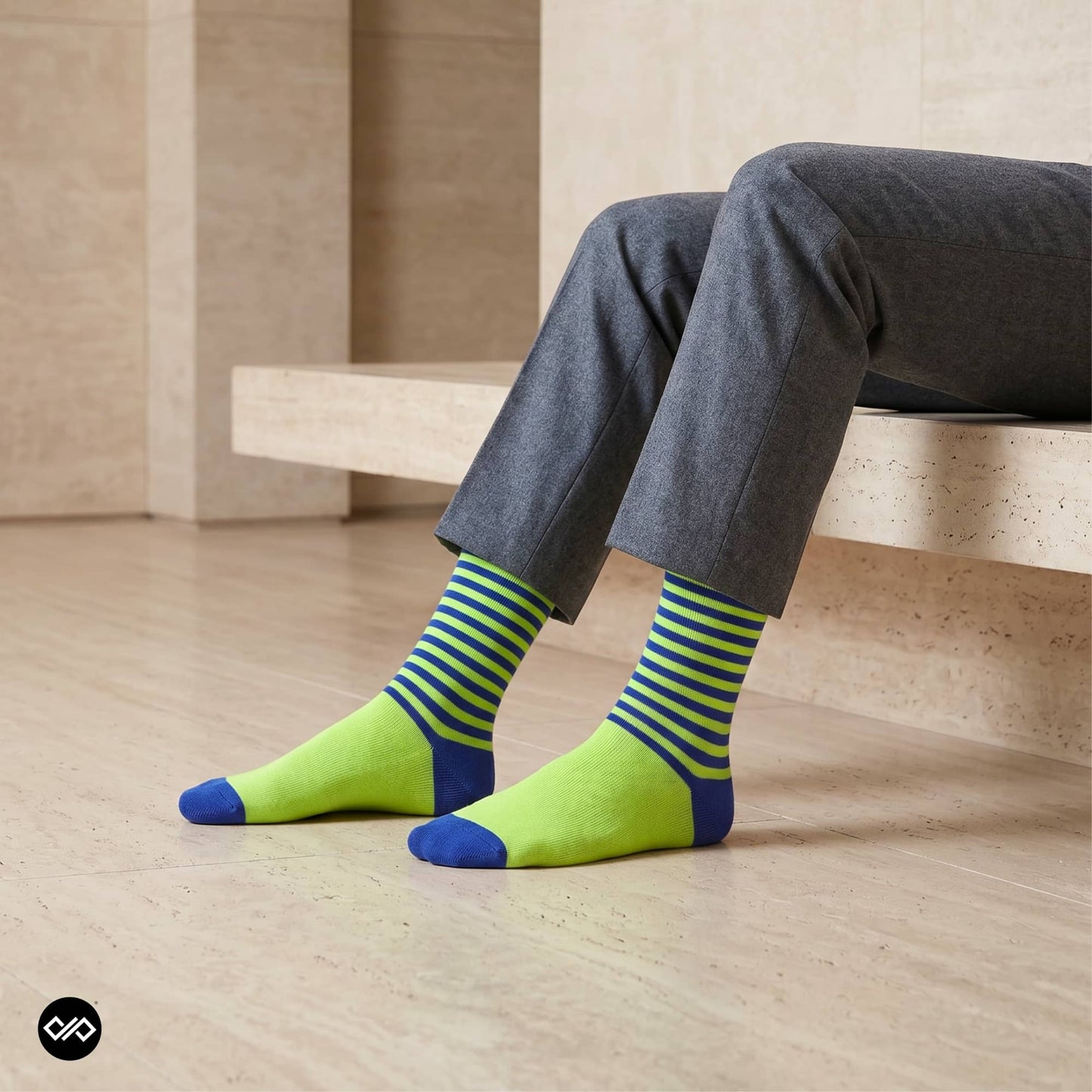 Neon green and blue striped crew socks for men with grey trousers on a travertine bench — premium combed cotton designer socks — Dynamocks