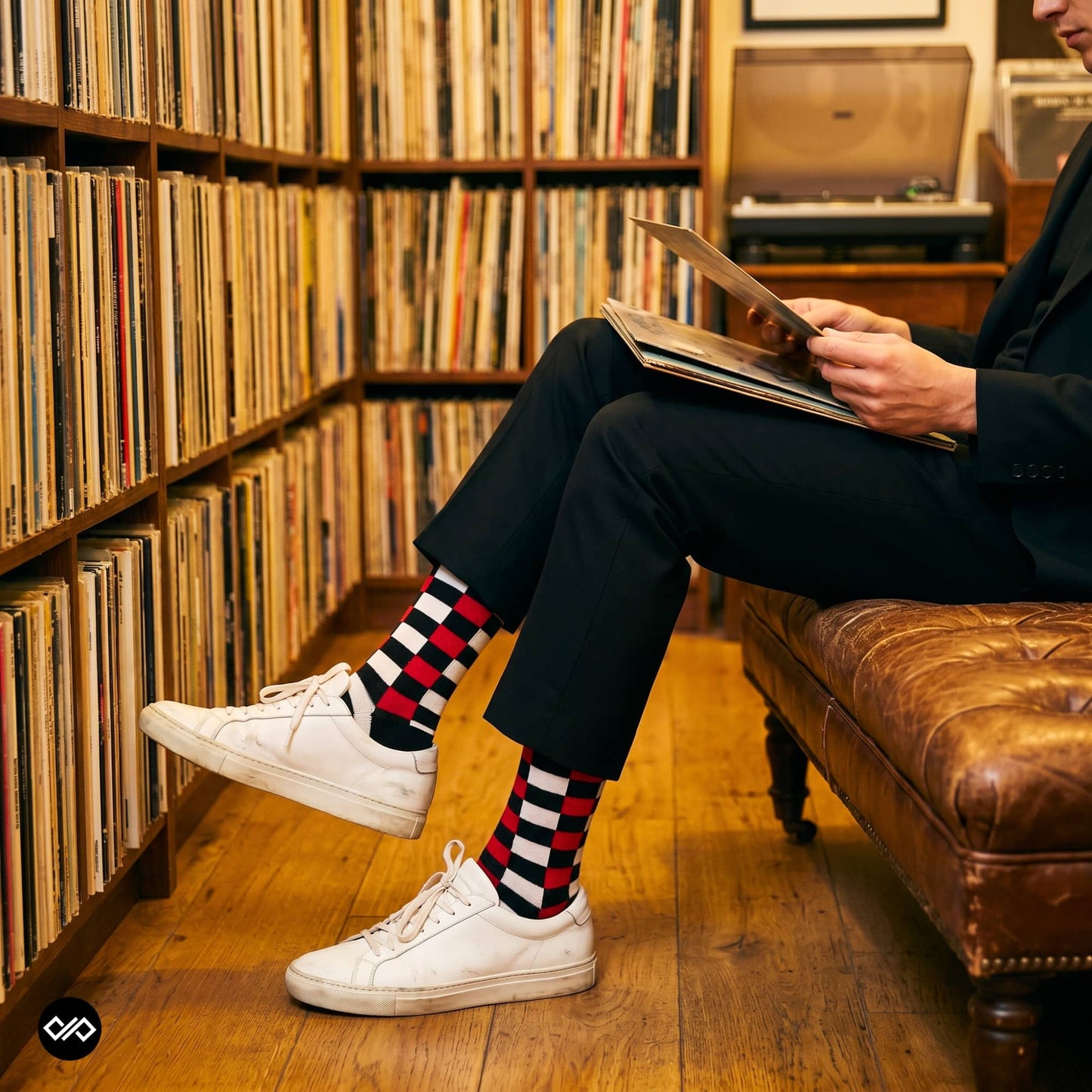 Sublime red check crew socks for men styled with black trousers and white sneakers in a vinyl record store — Dynamocks India