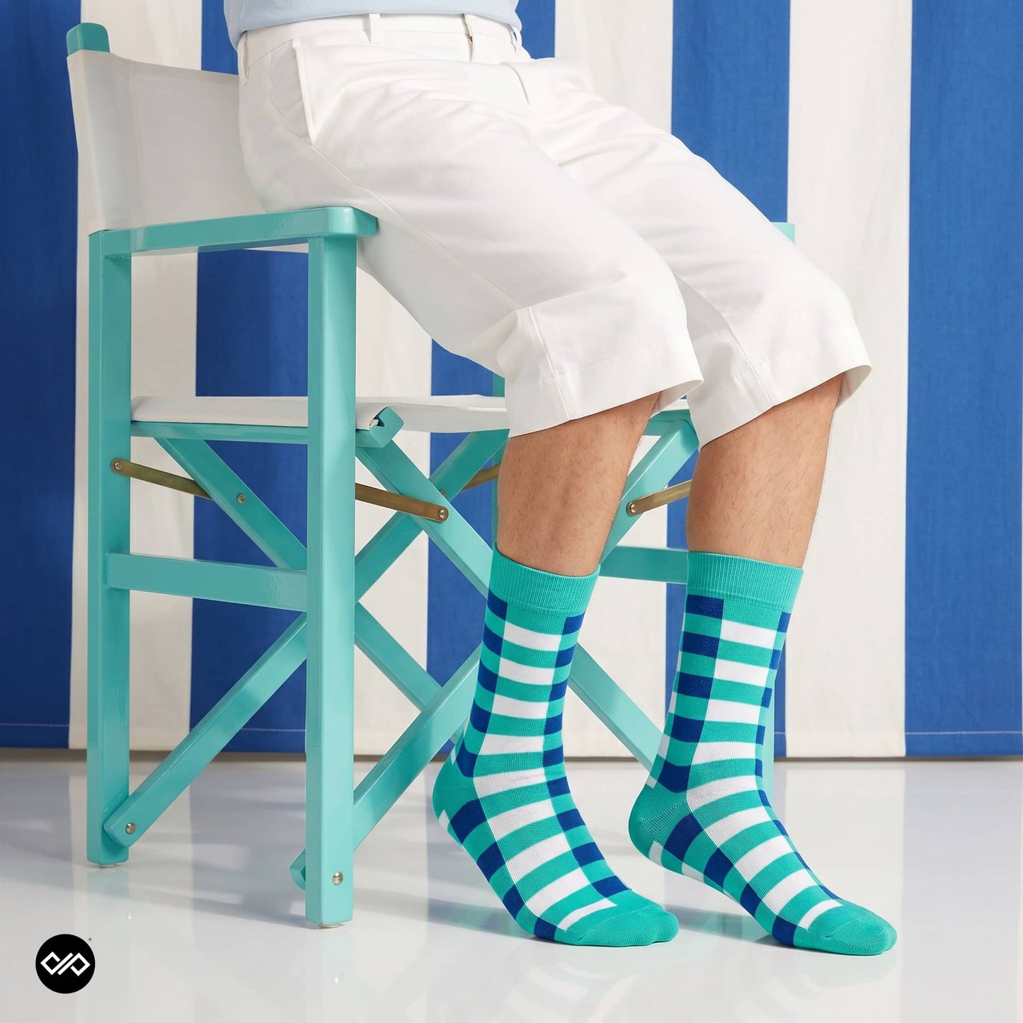 Sublime turquoise striped crew socks styled with white shorts and turquoise chair — Dynamocks