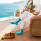 Sublime turquoise striped crew socks styled with white linen trousers and tan loafers on a Mediterranean terrace — Dynamocks India