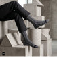 Trios geometric crew socks worn with black trousers in a modern concrete architectural setting — Dynamocks