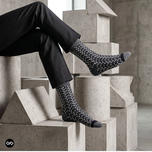 Trios geometric crew socks worn with black trousers in a modern concrete architectural setting — Dynamocks