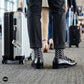 Trios geometric crew socks styled with charcoal trousers and black tassel loafers at an airport terminal — Dynamocks