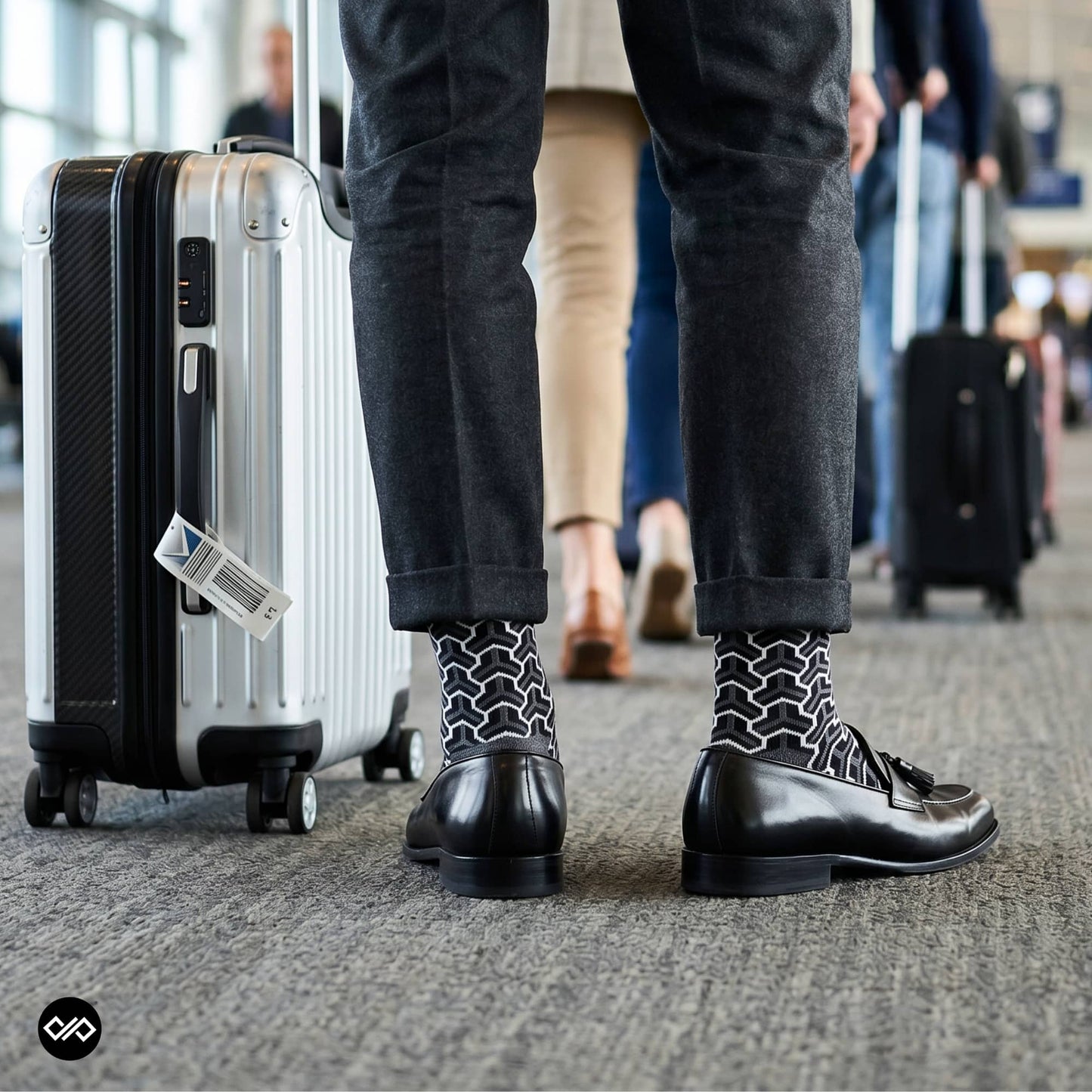 Trios geometric crew socks styled with charcoal trousers and black tassel loafers at an airport terminal — Dynamocks