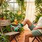 Watermelon crew socks for men styled with olive shorts in summer greenhouse — designer cotton socks — Dynamocks
